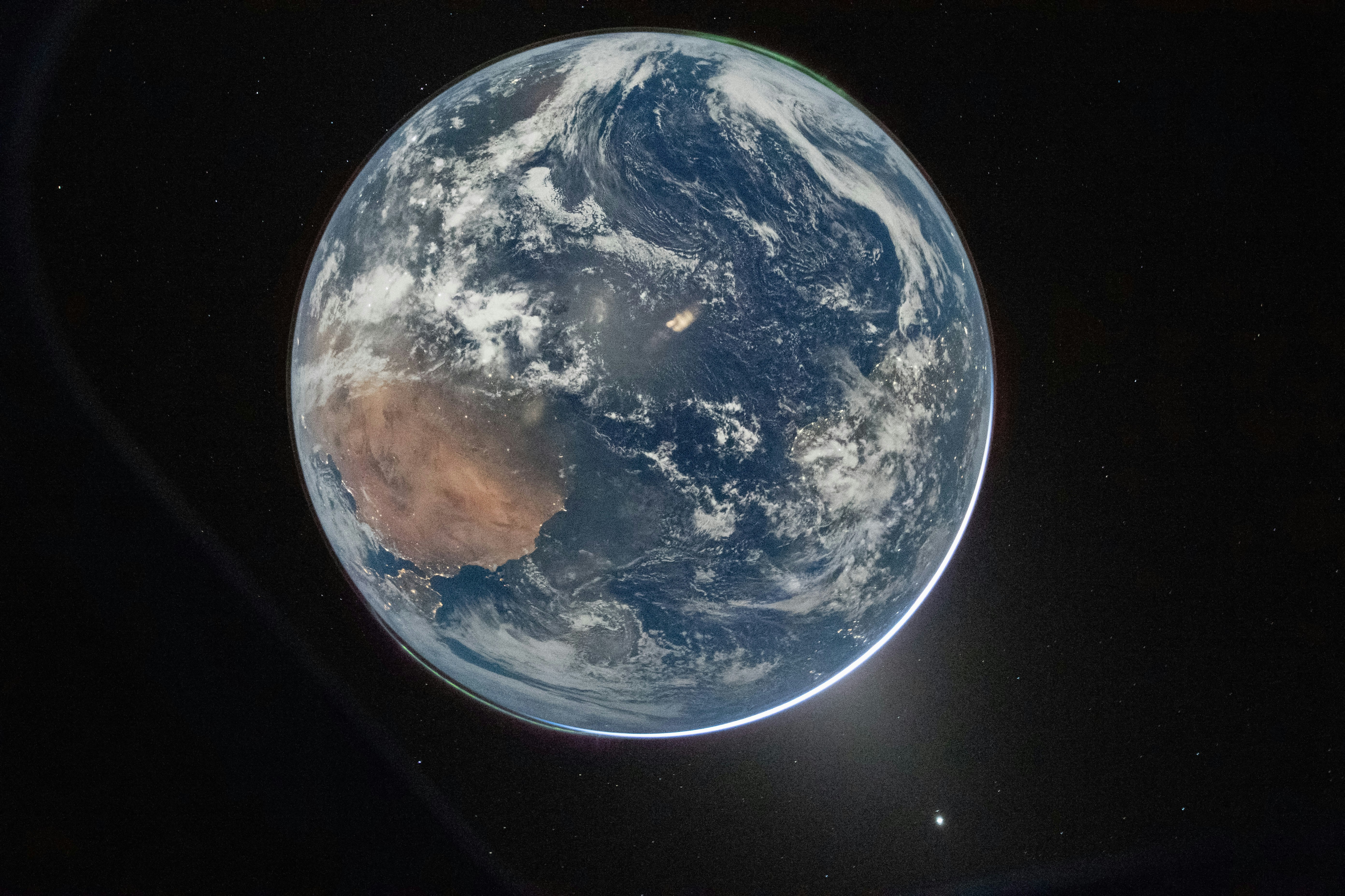 虹色の光線が描かれた暗い背景に浮かぶAstroのロゴ。
